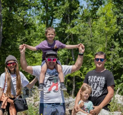 A joyful family enjoying a sunny day outdoors, captured in a lively and happy moment.